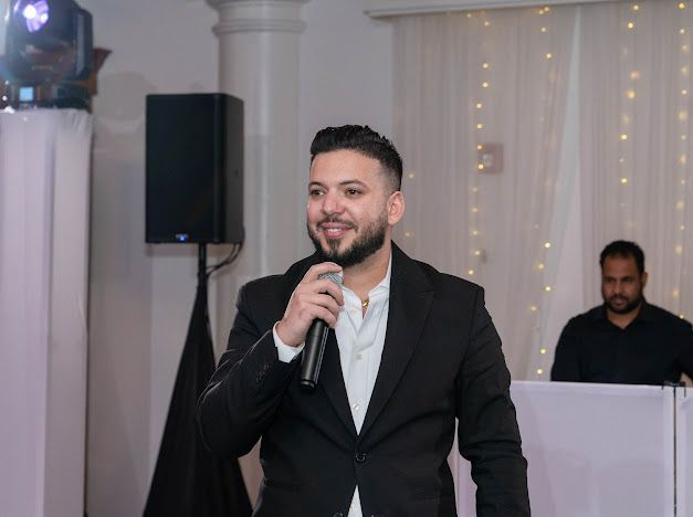 AJ, founder of ZEO Events, on the mic during a wedding reception