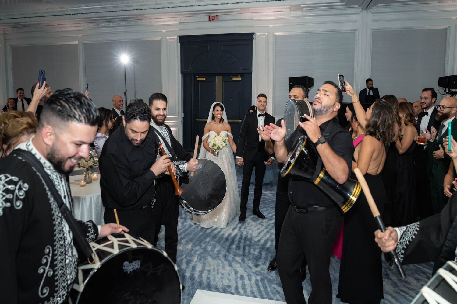 Zaffa performers and wedding party under the chandeliers