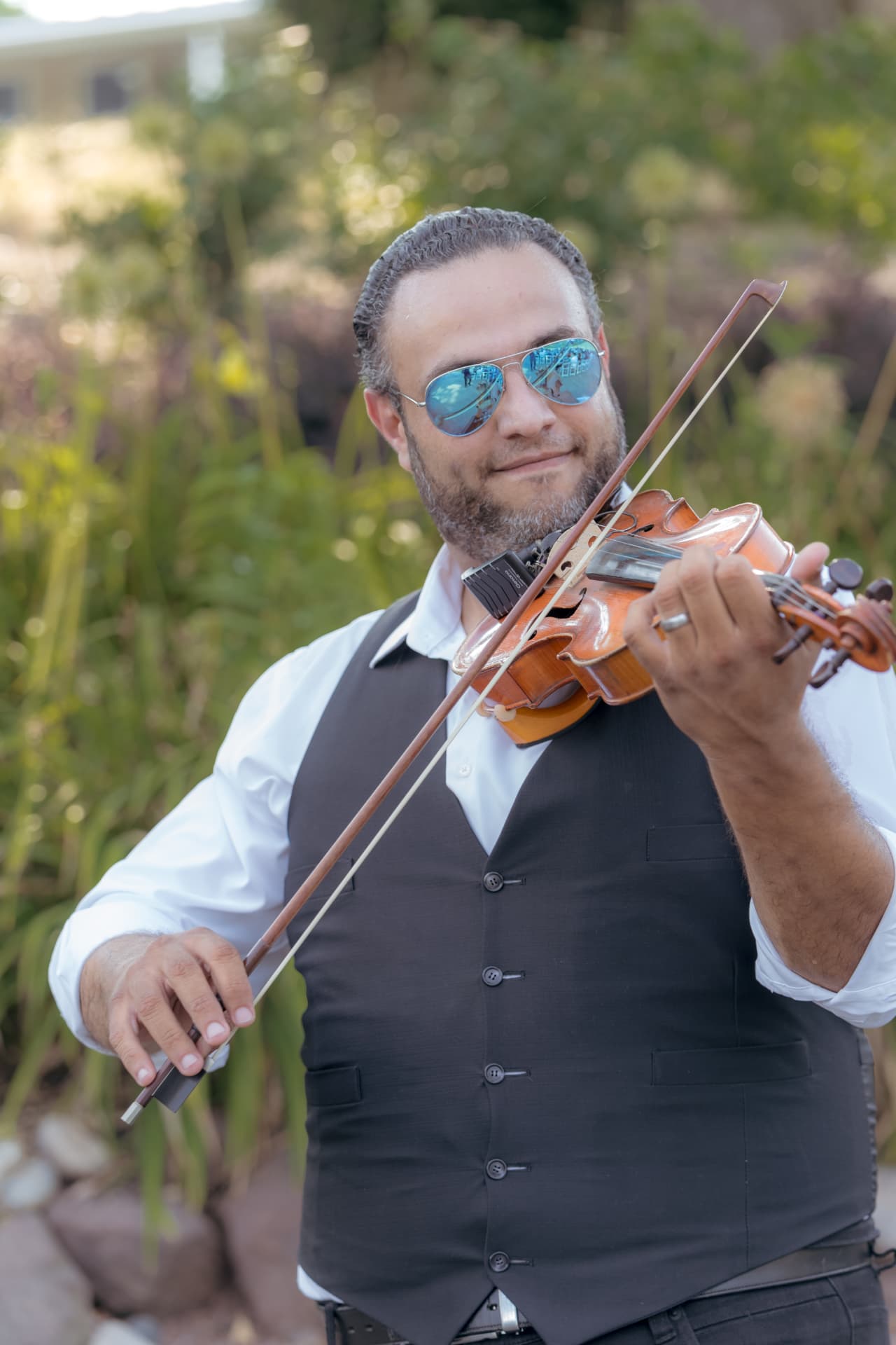 ZEO Entertainment violinist performing outdoors in a black vest and sunglasses