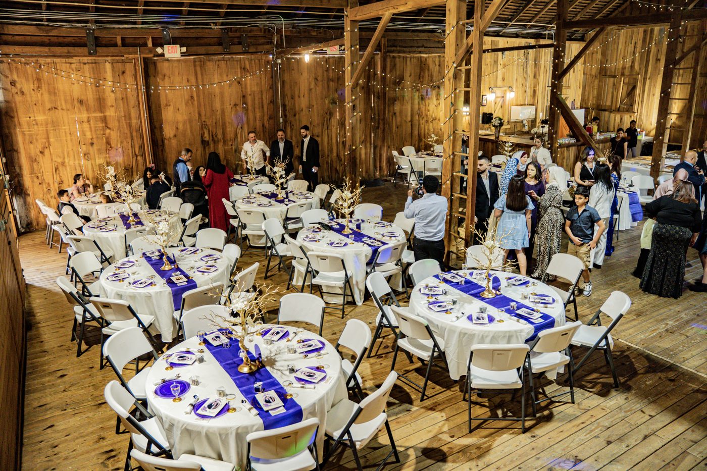 Eastern Shore tented reception with string lights and long farm tables