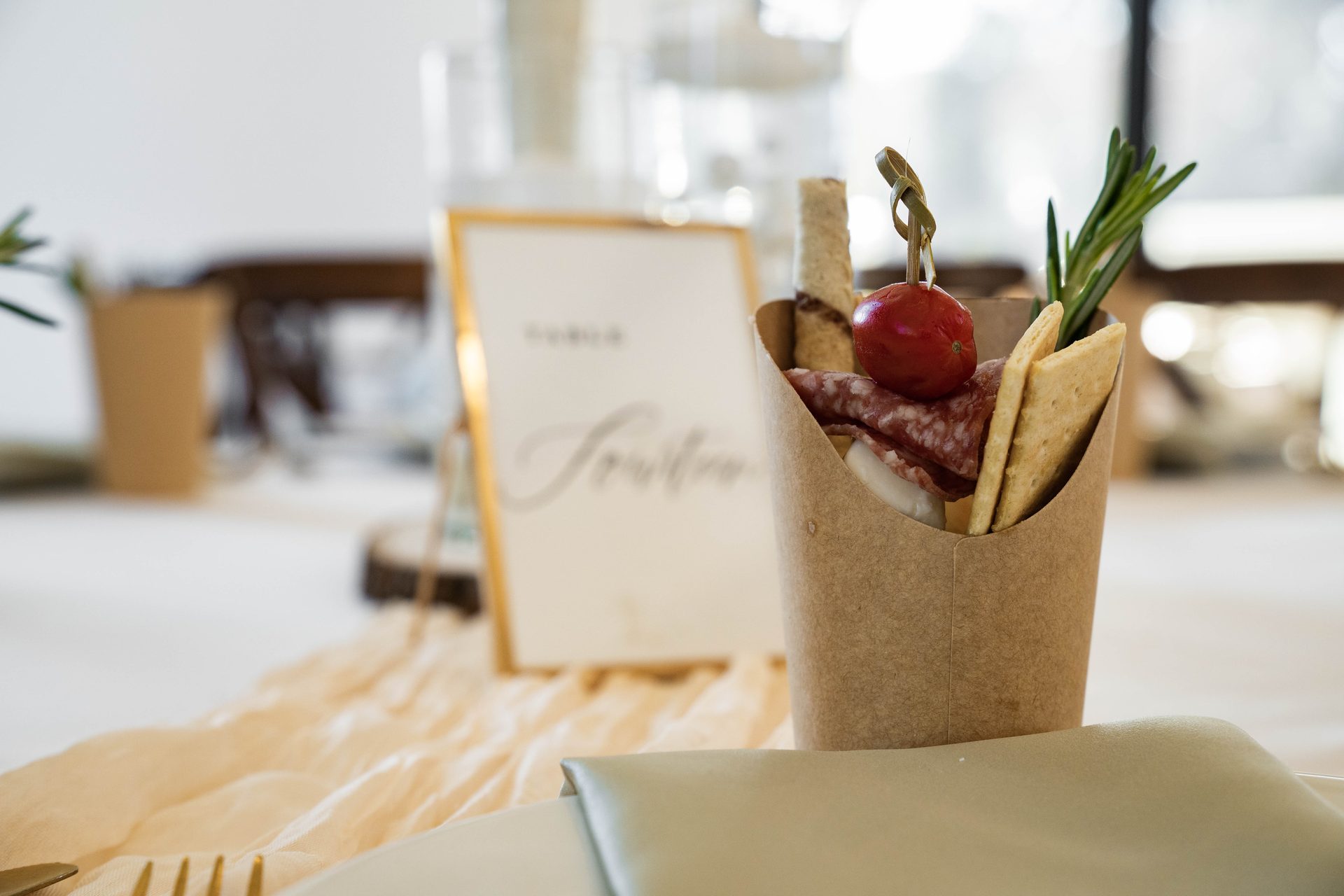 Individual charcuterie cup with salami, cheese, crackers and a table number card
