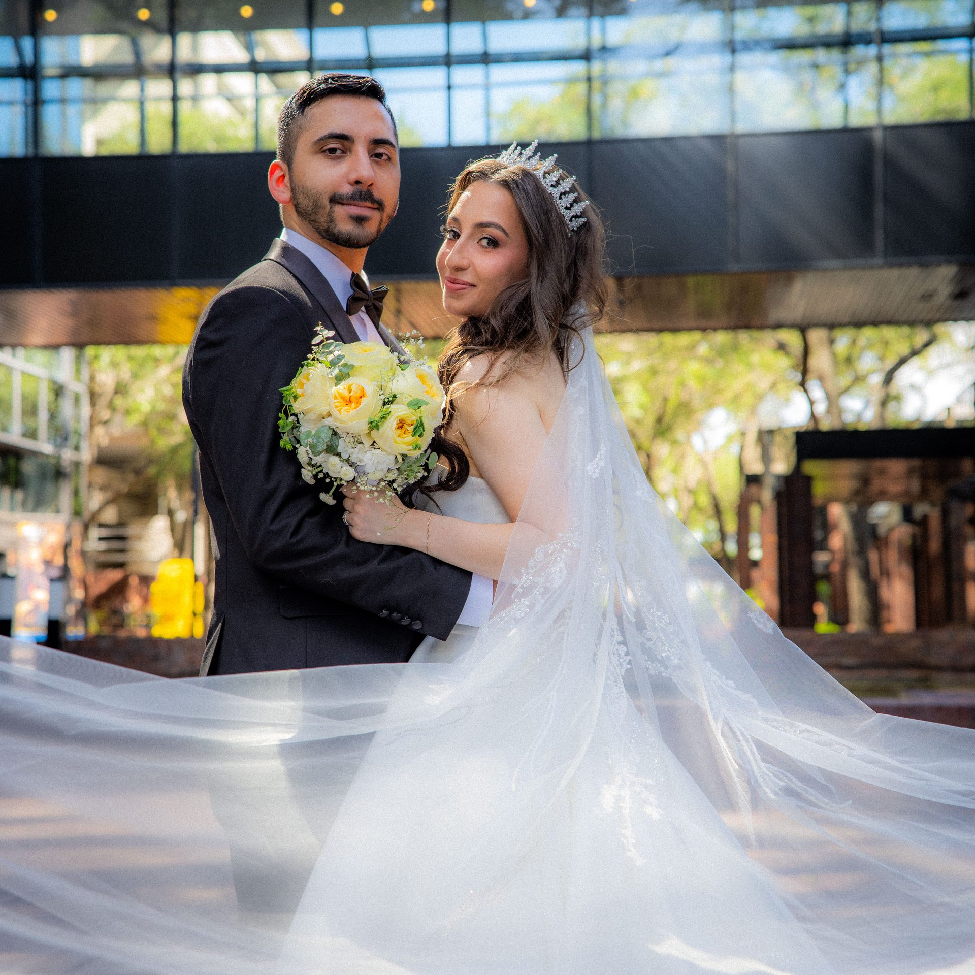 Couple portrait outdoors with the veil sweeping