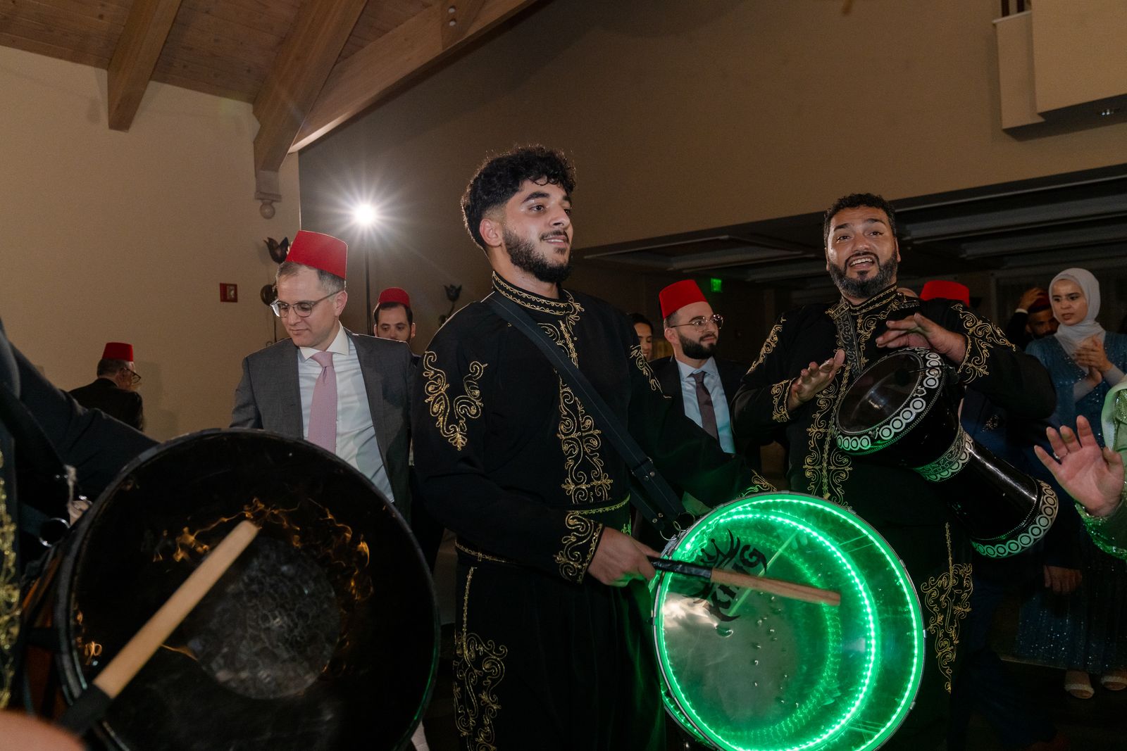 ZEO drummers playing green-lit LED drums as guests close in
